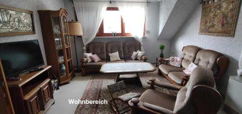 sala de estar con 2 sillas y TV en Ferienwohnung Katharina I en Alf