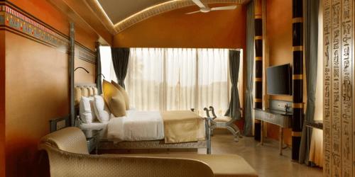 a bedroom with a bed and a window and a television at Neonz Resort & Club in Anand