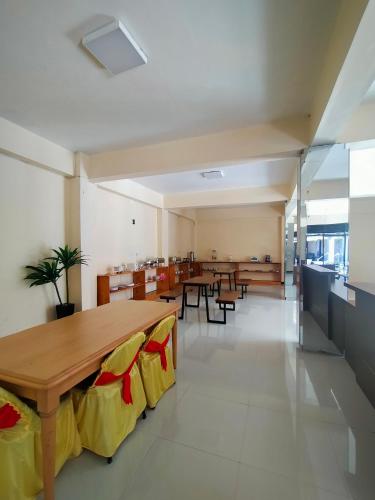a dining room with tables and chairs and a cafeteria at Wisma Samrat in Rantepao