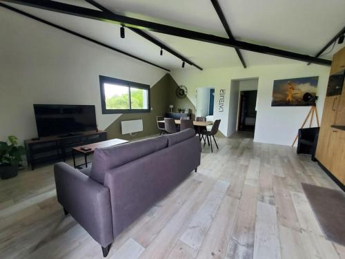 un salon avec un canapé violet et une table dans l'établissement L'ATELIER 5 couchages, à Malville