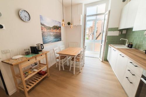 una cucina e una sala da pranzo con un tavolo e un orologio di BnBina2: nel centro di Chiavari a Chiavari