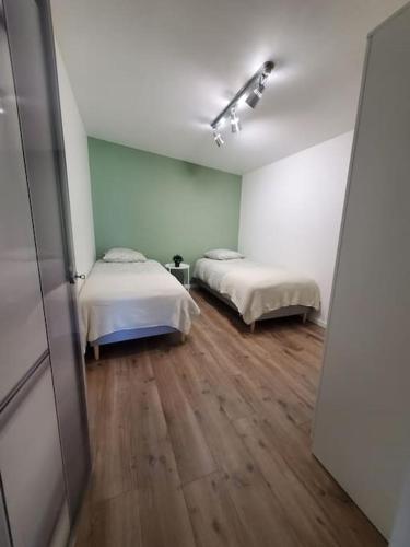 Cette chambre dispose de deux lits et de parquet. dans l'établissement L'ATELIER 5 couchages, à Malville