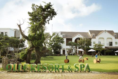 a sign that reads oliver reserve and spa with people riding horses at Olle Resort in Jeju
