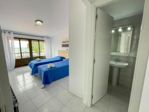 1 dormitorio con 2 camas, lavabo y espejo en Complejo Tamanaco Illa de Arousa 3000, en A Illa de Arousa