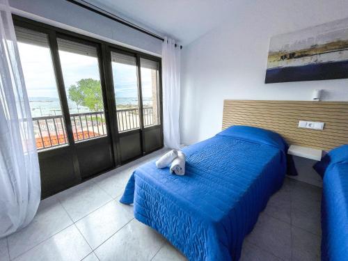 um quarto com uma cama com um bicho de peluche em Hostal Tamanaco Illa de Arousa 3000 em Ilha de Arousa