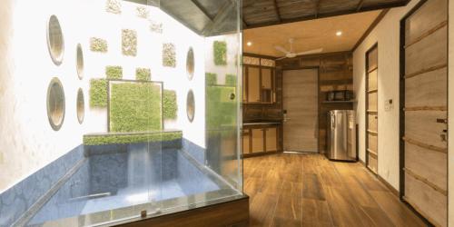 a kitchen with a large aquarium in the middle of a room at Neonz Resort & Club in Anand