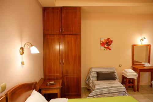 a bedroom with a bed and a cabinet and a mirror at Archontiko tou Ziaka in Ipáti