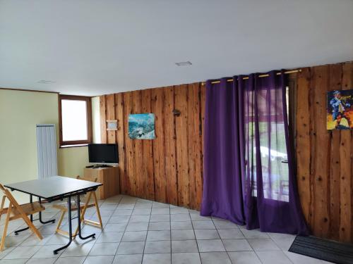 a room with a table and a purple curtain at Gîte de la Peyrouse in Saint-Jean-de-Vaux