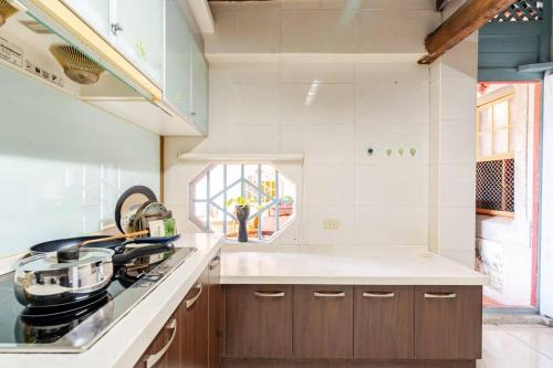 a kitchen with a stove and a sink and a window at 臺窩灣Tayouan Villa2024全新房間設備包棟不分租,4房6衛4床2廳1廚房,安平古堡老街走路1分鐘,花園夜市15分 in Anping