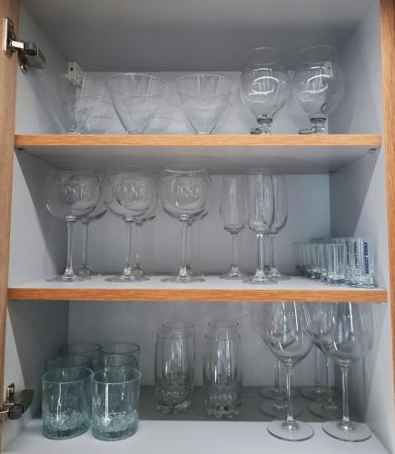 a bunch of wine glasses sitting on a shelf at Apartament Madlen Kalinowa Szczyrk Sauna Grota Solna in Szczyrk