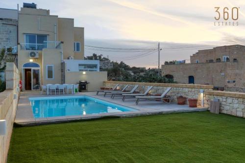 a backyard with a swimming pool and some chairs at LUX Villa with Private Pool, BBQ & Rooftop Oasis by 360 Estates in Il-Wileġ
