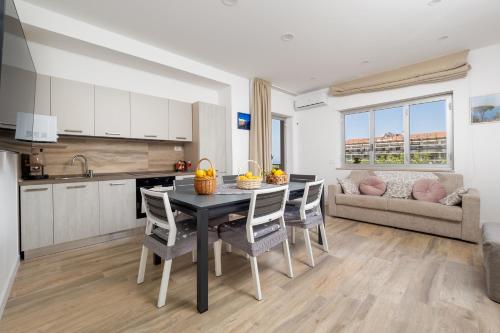 une cuisine et un salon avec une table et des chaises dans l'établissement Nonno Angelo - 4 Bedrooms with Free Parking & Seaview Balcony, à Sorrente