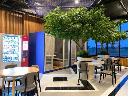 a restaurant with tables and chairs and a tree at tt Residence in Chachoengsao