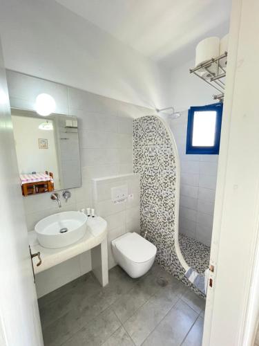 ペリヴォロスにあるThalassitis Coastal Apartmentsの洗面台とトイレを備えた白いバスルーム