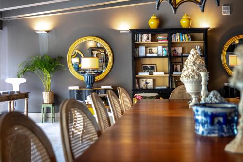 a dining room with a table and chairs and mirrors at Maison La Herrería B&B in Villanueva de Henares