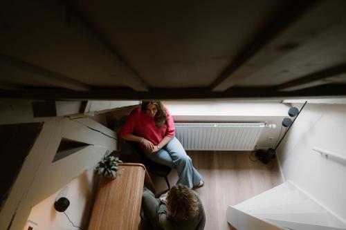 a woman sitting on a bench in a room at Stadsklooster Dordt Hotel&Hostel in Dordrecht