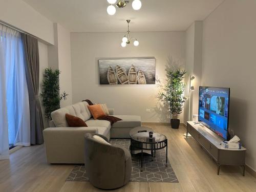 uma sala de estar com um sofá e uma televisão em Partial Canal View 1br Apartment Yas Island em Abu Dhabi
