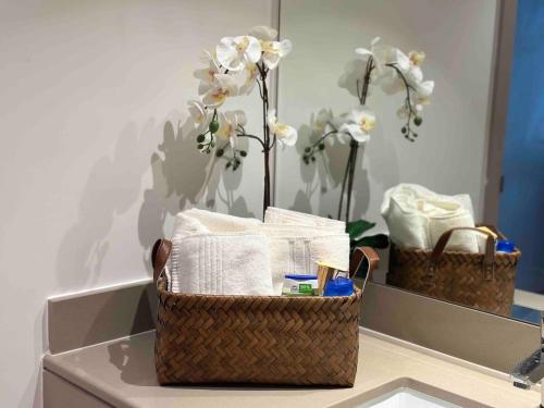 a basket with towels and flowers in a mirror at Yas Island 1br By Skyhomes in Abu Dhabi