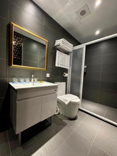 a bathroom with a sink and a toilet and a mirror at Airline Inn Ximen in Taipei