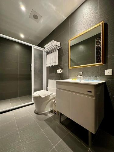 a bathroom with a toilet and a sink and a mirror at Airline Inn Ximen in Taipei