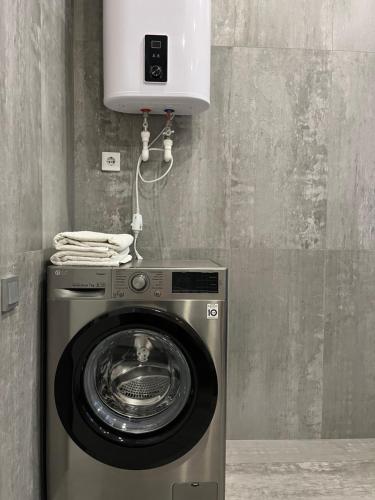 eine Waschmaschine in einem Zimmer mit einer Mikrowelle in der Unterkunft Апартаменты люкс класса in Pawlodar