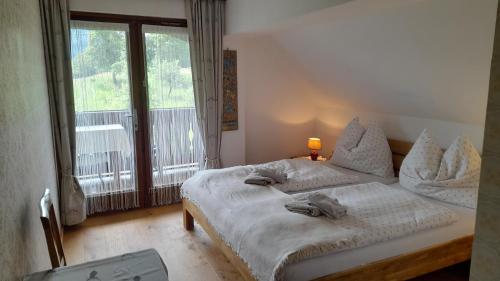 a bedroom with a bed and a large window at Ferienwohnung Johanna in Sankt Georgen im Gailtal