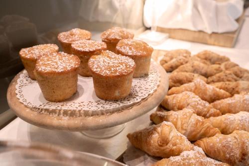 a plate of muffins and other pastries on a table at Il Portico - 1711 Luxury Guest House in Arlate