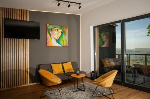 a living room with a couch and a tv at DOG HILL Apartman in Dunabogdány