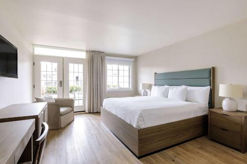 a hotel room with a bed and a couch at Balcomo, a Ramada by Wyndham in Penticton