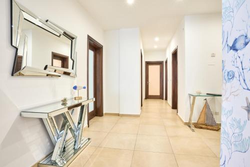 a hallway with white walls and a mirror and a tile floor at Stunning 3-Bedroom Seaview Retreat in Fort Cambridge in Sliema