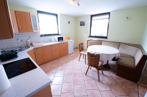 - une cuisine avec une table, une table et des chaises dans l'établissement APARTMA JAKOPIČ, à Zgornje Gorje
