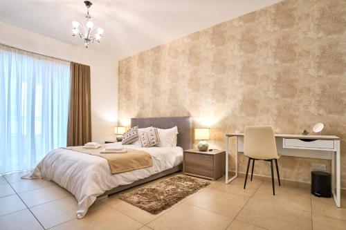 a bedroom with a bed and a desk with a chair at Stunning 3-Bedroom Seaview Retreat in Fort Cambridge in Sliema