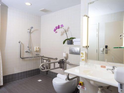La salle de bains est pourvue de toilettes et d'un lavabo. dans l'établissement Ibis Singapore on Bencoolen, à Singapour
