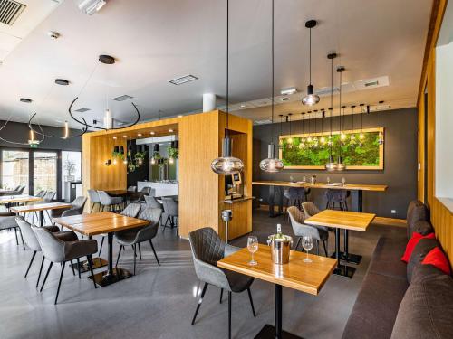 a restaurant with tables and chairs and a couch at Ibis Hotel Plzeň in Pilsen