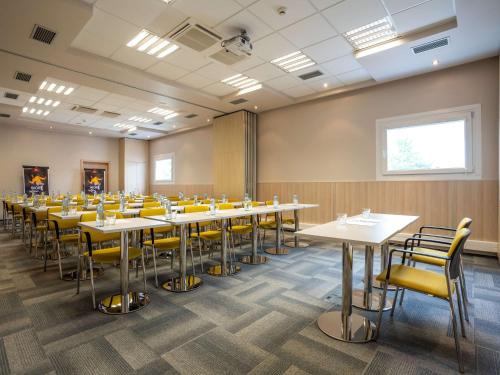 uma sala de conferências com mesas e cadeiras amarelas em Ibis Hotel Plzeň em Plzeň