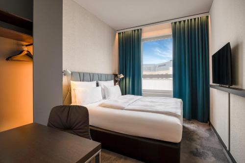um quarto de hotel com uma cama e uma janela em Motel One Brussels em Bruxelas