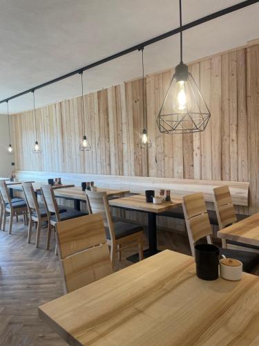 ein Restaurant mit Holzwänden, Tischen und Stühlen in der Unterkunft Müller's Stuben in Isny im Allgäu