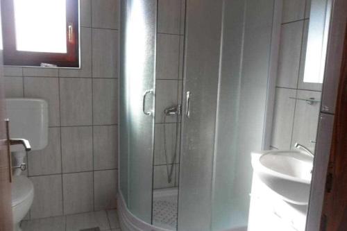 y baño con ducha, aseo y lavamanos. en Ivago Apartments, en Privlaka