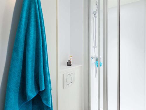 - Baño con toalla azul junto a una ducha en hotelF1 Avignon Nord, en Sorgues
