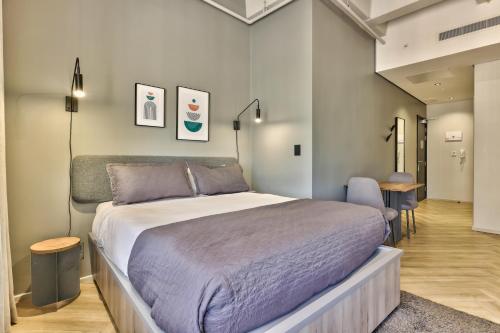 a bedroom with a large bed and a hallway at WINK Aparthotel One Thibault in Cape Town