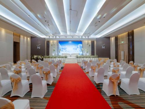 a banquet hall with white chairs and a red carpet at Novotel Phuket City Phokeethra in Phuket