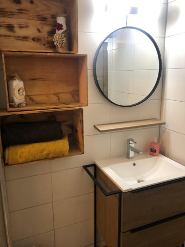 une salle de bain avec un lavabo et un miroir dans l'établissement Maison hyper centre, à Cognac
