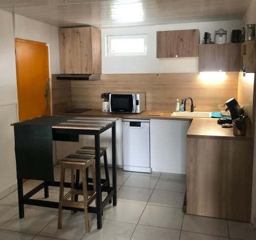 une petite cuisine avec une table et un micro-ondes dans l'établissement Maison hyper centre, à Cognac