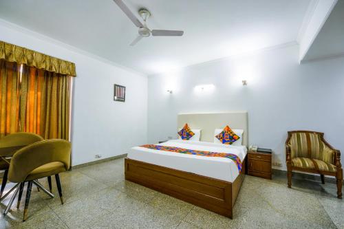 Schlafzimmer mit einem Bett, einem Tisch und Stühlen in der Unterkunft FabHotel Exotica Galleria Market, Gurgaon in Gurgaon