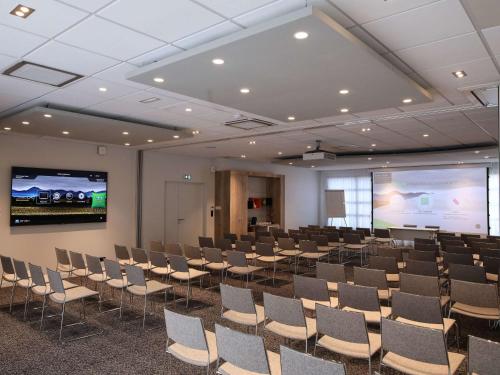 a room with rows of chairs and a projection screen at Ibis Styles Clermont-Ferrand République in Clermont-Ferrand