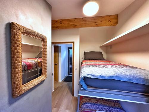 a bedroom with a bed and a mirror on the wall at Chy Cos. South facing lodge with balcony & views. in St. Agnes 