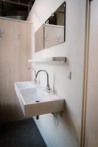 a bathroom with a white sink and a mirror at Stadsklooster Dordt Hotel&Hostel in Dordrecht