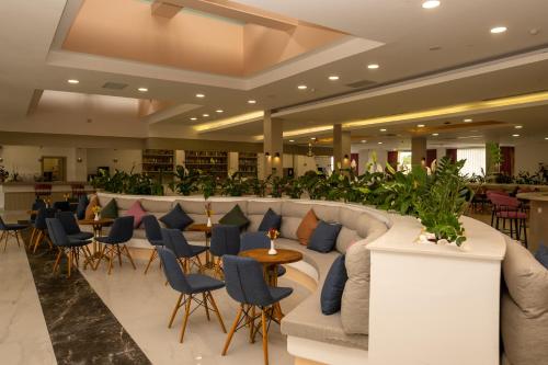 vestíbulo del hotel con sofá, sillas y bar en Holiday Village Türkiye en Dalaman