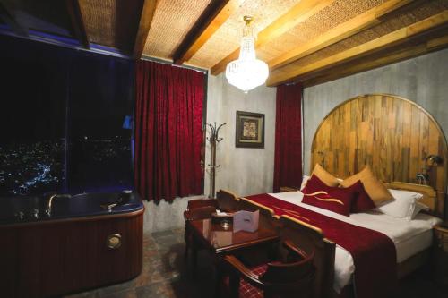 a bedroom with a bed and a table and a window at Bay Lodge Boutique Hotel in Jounieh