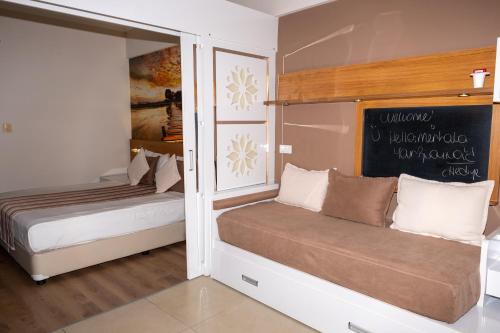 a bedroom with two beds and a chalkboard on the wall at Holiday Village Türkiye in Dalaman